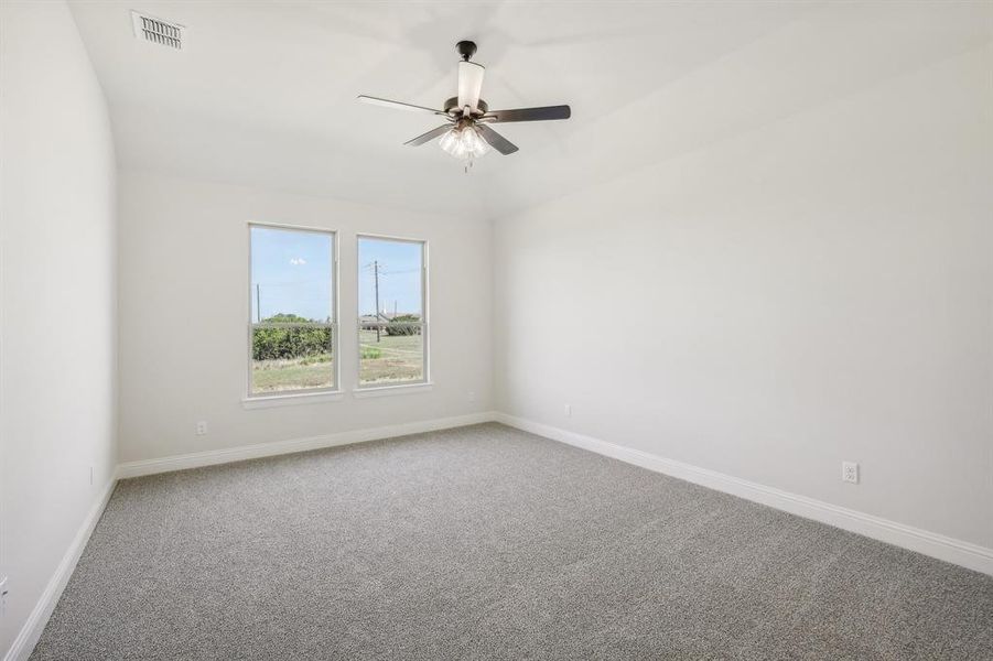 Carpeted empty room featuring ceiling fan