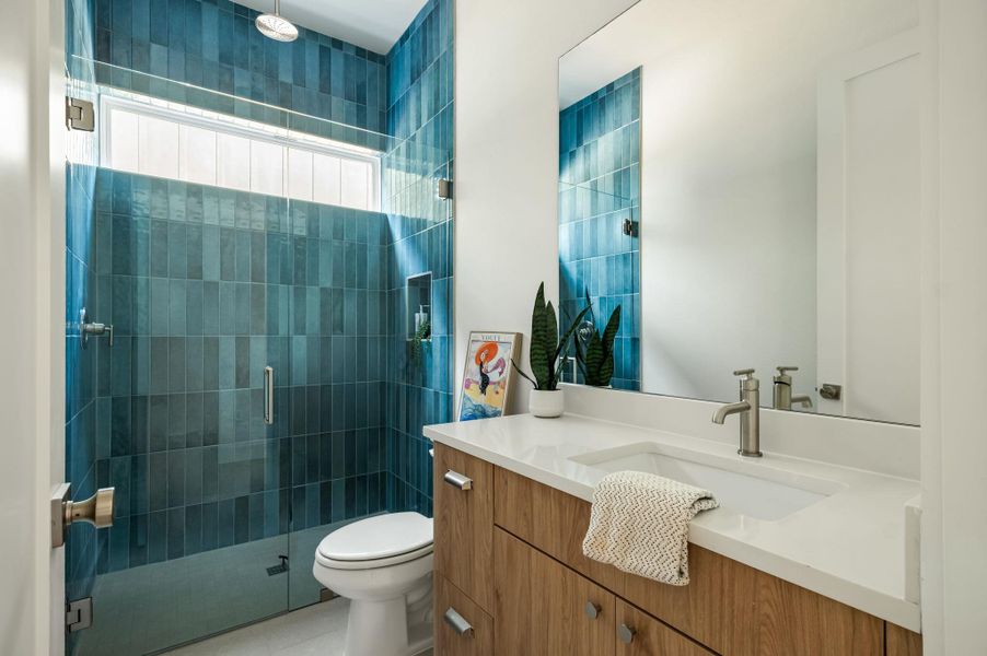 Sleek vanity and shower with floor-to-ceiling tiling create a modern aesthetic in this refreshing bathroom. Sleek vanity and shower with floor-to-ceiling tiling create a modern aesthetic in this refreshing bathroom.