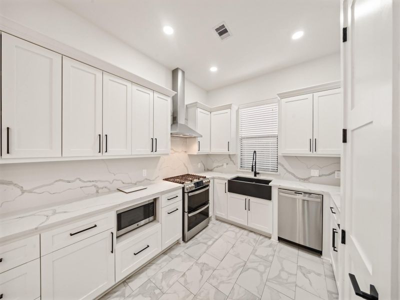 Kitchen: double stainless steel oven and vent hood, window blinds, and micro-wave