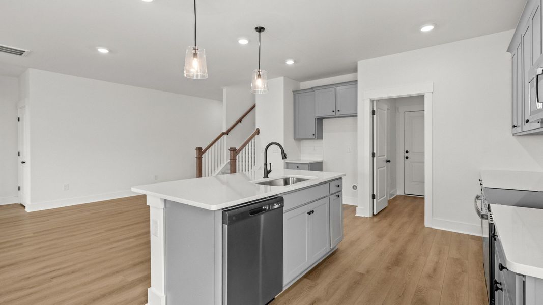 Stylish kitchen design with upgraded tile backsplash and quartz counters.