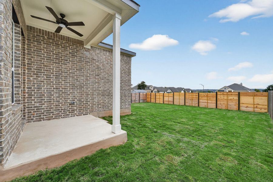 Fenced backyard featuring ceiling fan, a patio, and a residential view