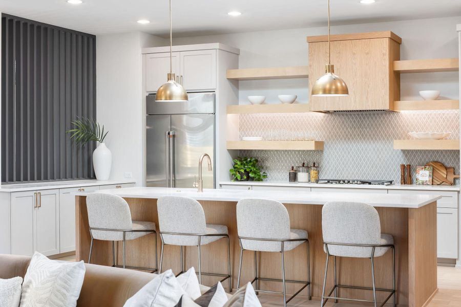 Kitchen with open shelves, backsplash, stainless steel built in refrigerator, and light countertops