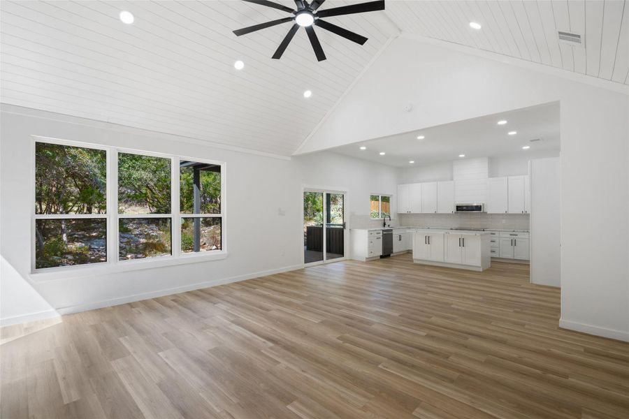 Unfurnished living room with high vaulted ceiling, light wood finished floors, recessed lighting, ceiling fan, and wood ceiling Unfurnished living room with high vaulted ceiling, light wood finished floors, recessed lighting, ceiling fan, and wood ceiling