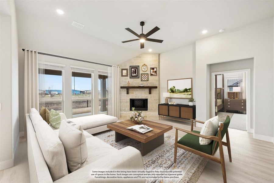 Living room with vaulted ceiling, stone fireplace, ceiling fan, and large windows with outdoor view Living room with vaulted ceiling, stone fireplace, ceiling fan, and large windows with outdoor view