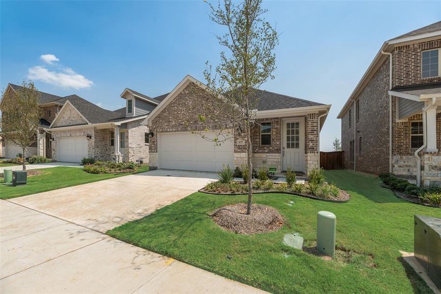 Front exterior of a new home in Spiritas Ranch, Little Elm, TX, highlighting curb appeal (Image 14). Front exterior of a new home in Spiritas Ranch, Little Elm, TX, highlighting curb appeal (Image 14).