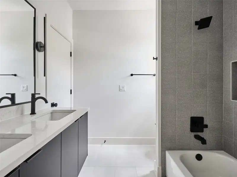 Full bath featuring double vanity, bathtub / shower combination, and light tile patterned flooring Full bath featuring double vanity, bathtub / shower combination, and light tile patterned flooring