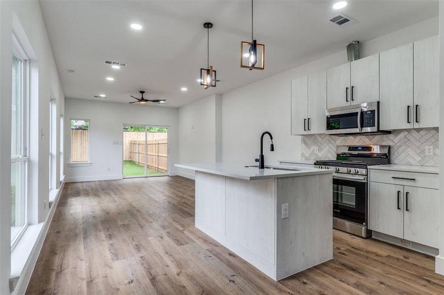Open floorplan with kitchen counter island and pendant overhead lights