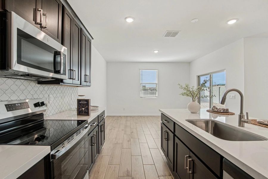 Kitchen and dining. Virtually staged. Options and finishes may vary.