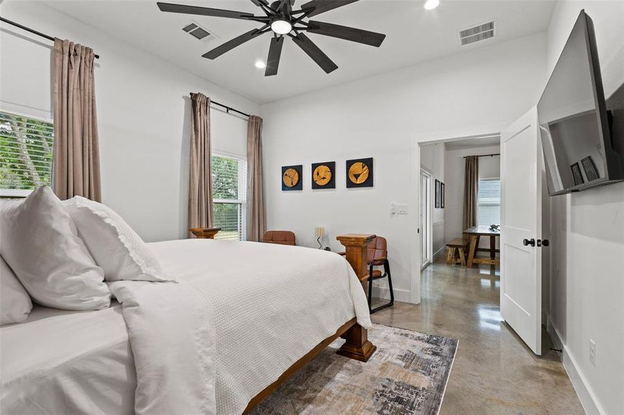 Bedroom featuring finished concrete floors, multiple windows, recessed lighting, and ceiling fan