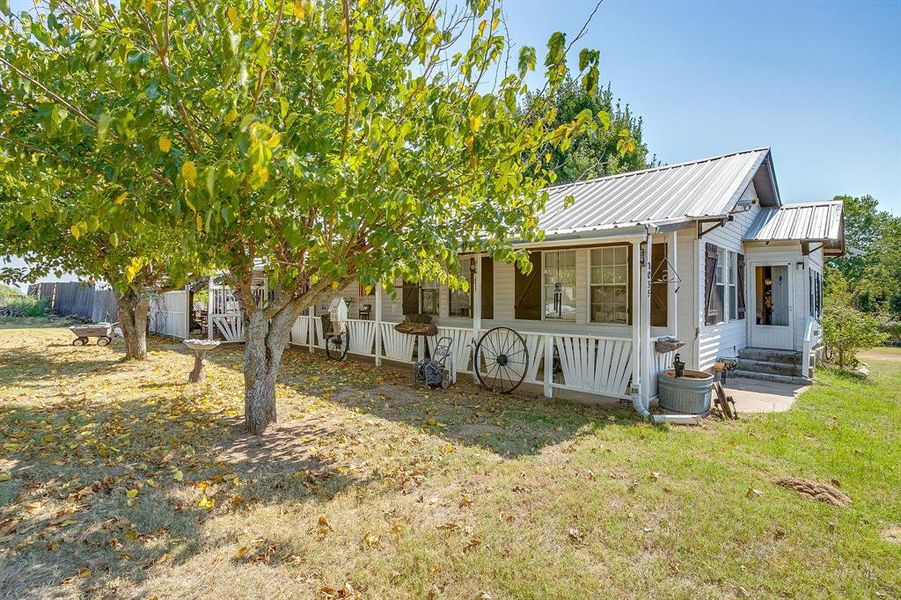 View of front of property with a front lawn, a sunroom, and a metal roof View of front of property with a front lawn, a sunroom, and a metal roof