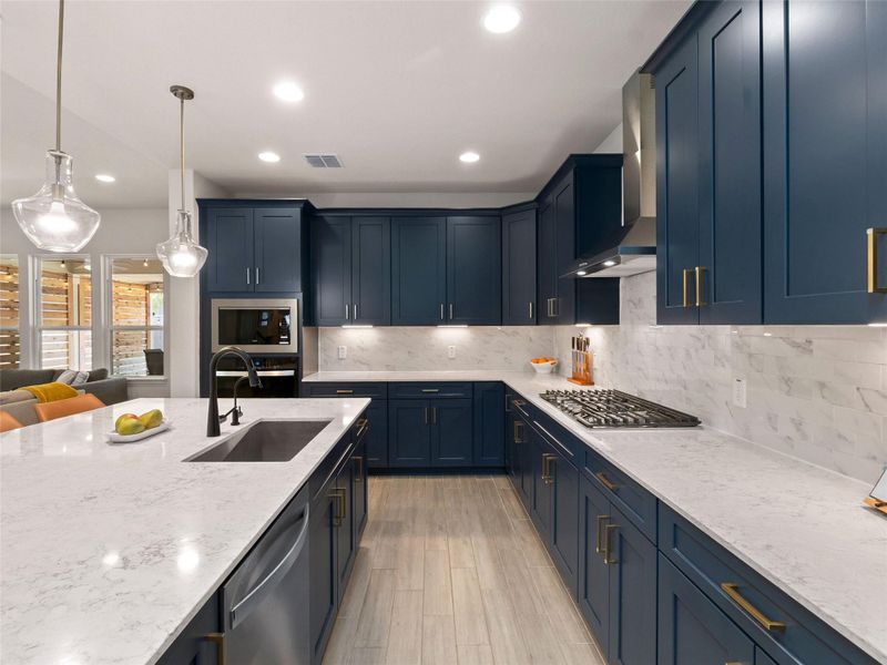 Kitchen with light stone counters, decorative light fixtures, tasteful backsplash, stainless steel appliances, and tile flooring