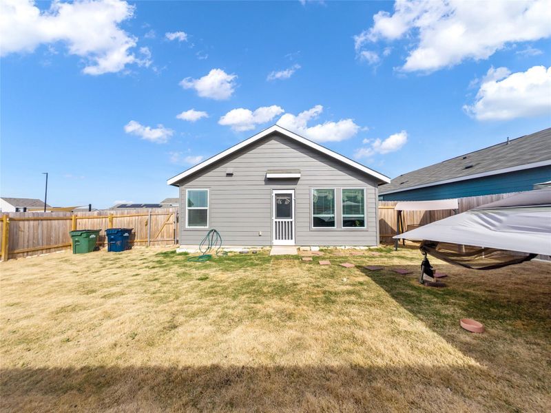 Back of house with a fenced backyard