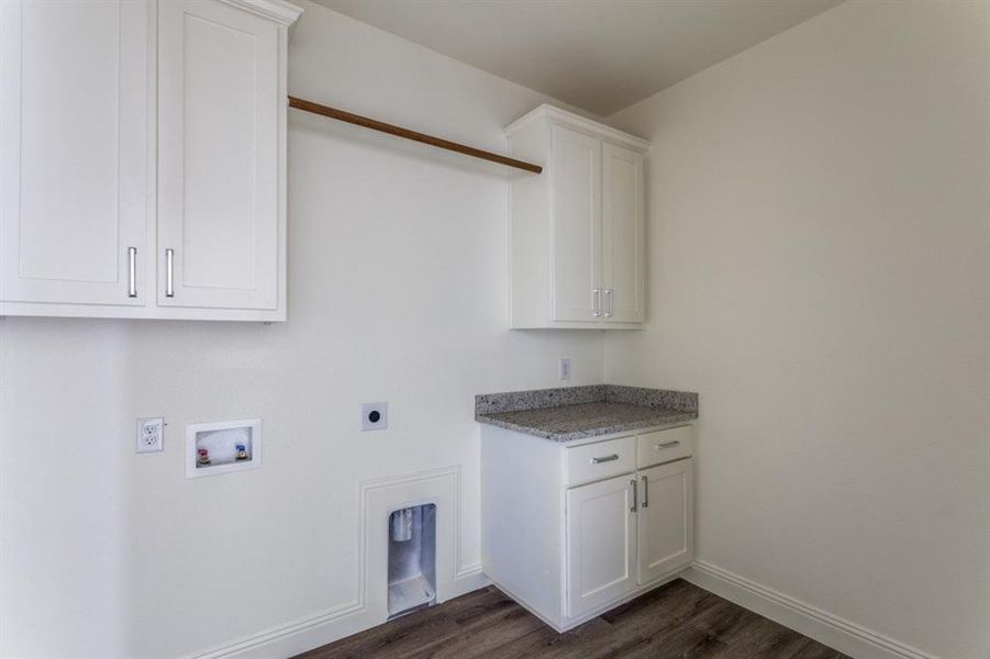 Washroom featuring cabinet space, washer hookup, dark wood-style floors, electric dryer hookup, and baseboards