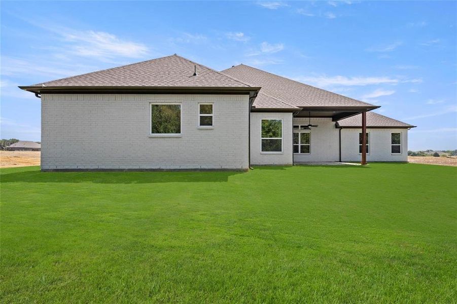 Back of property with a lawn and a patio