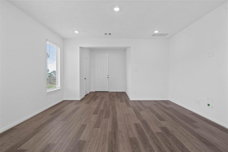 An inviting entryway welcomes you into the home, transitioning smoothly into a bright and spacious open living area. The functional foyer features crisp white walls, modern recessed lighting, and a convenient storage closet just off the door to keep coats and daily essentials neatly tucked away out of sight.