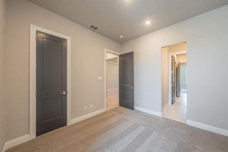 Carpeted room with light neutral wall tones and white baseboards