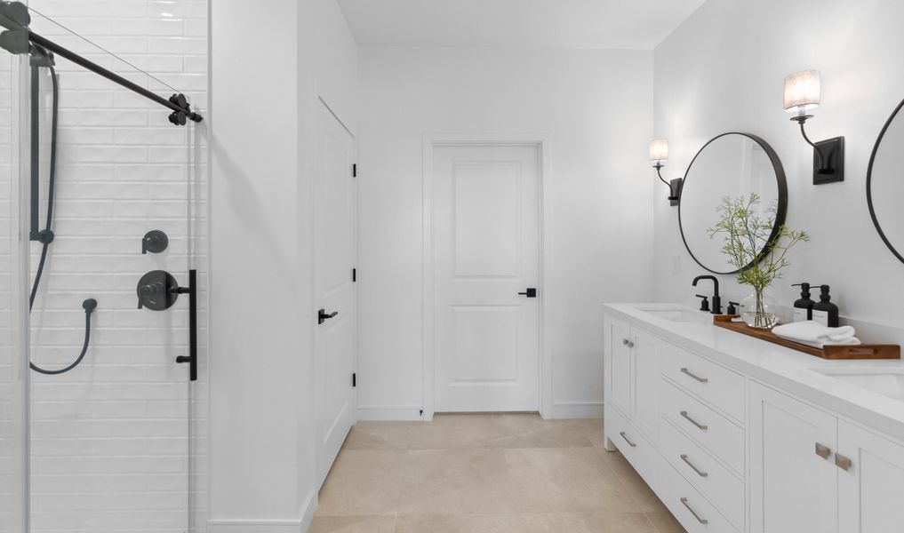 Primary bath with circular mirrors and matte black fixtures Primary bath with circular mirrors and matte black fixtures