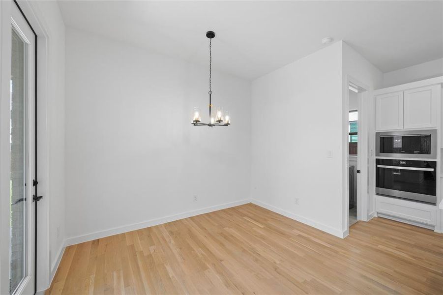 Light wood-finish flooring with white baseboards throughout