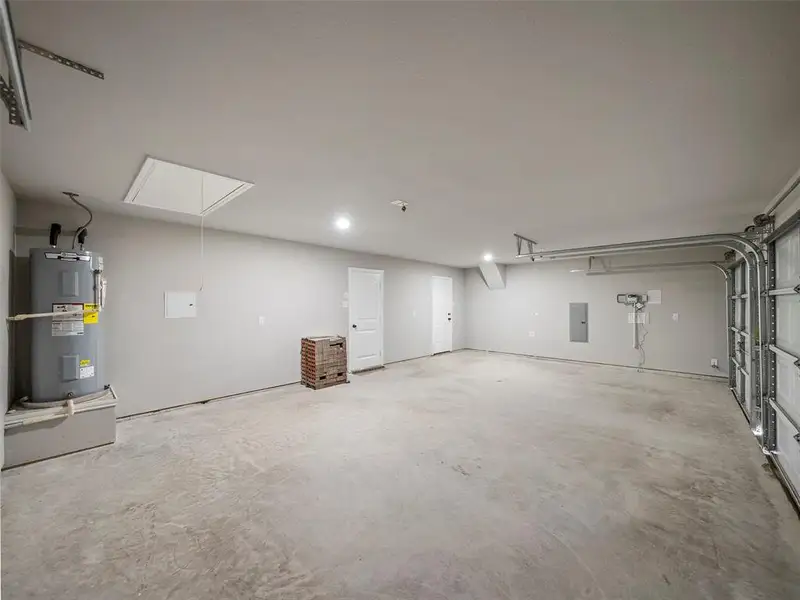 Garage featuring electric panel and water heater