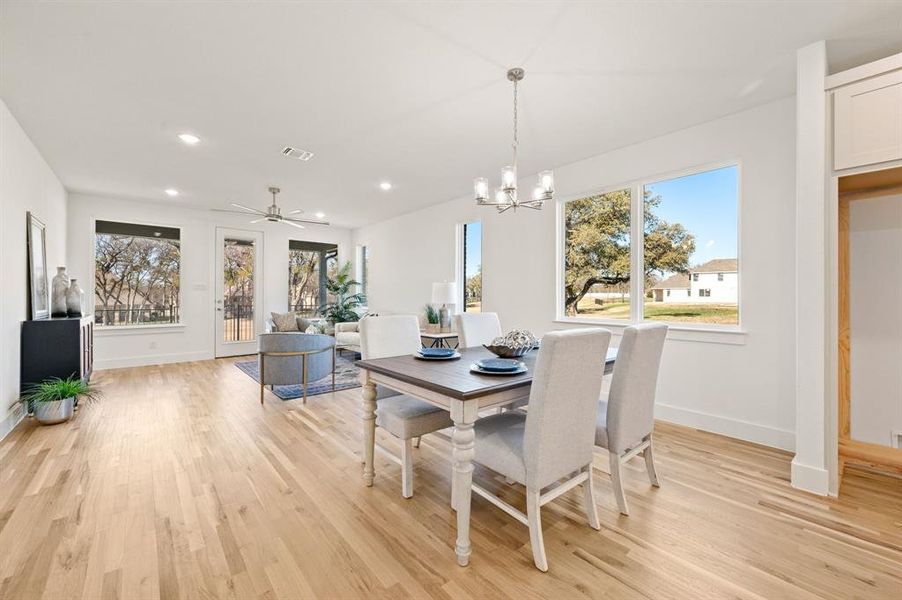 Dining space featuring a ceiling fan, hanging lights, and light wood finished floors