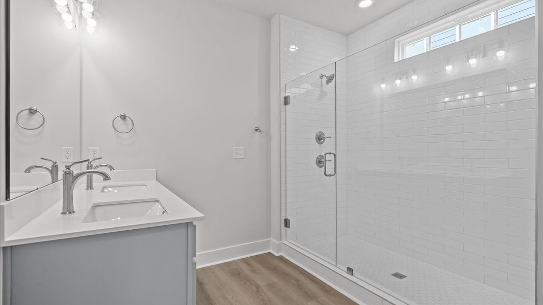 Highly functional and elegant en-suite with dual vanities, tiled walk-in shower, and refined finishes