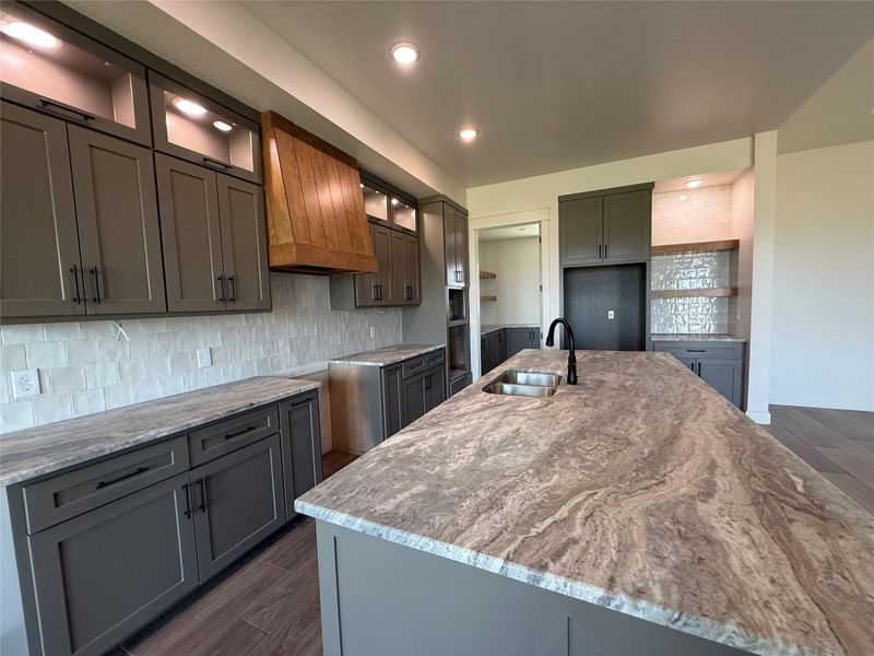 An inviting kitchen features a spacious island with dual sinks, sleek cabinetry, and integrated lighting.