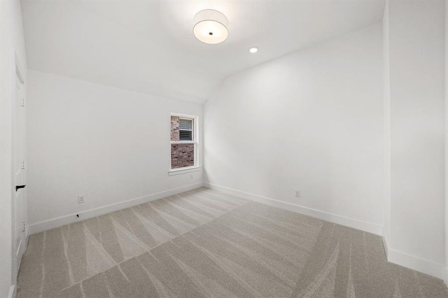 Spare room with lofted ceiling, light carpet, and recessed lighting