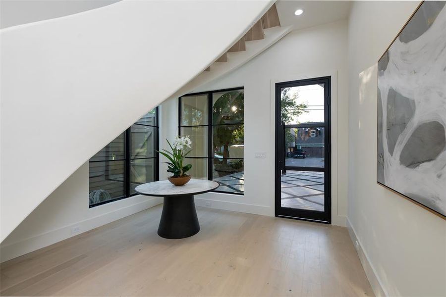 Entryway with wood finished floors and recessed lighting