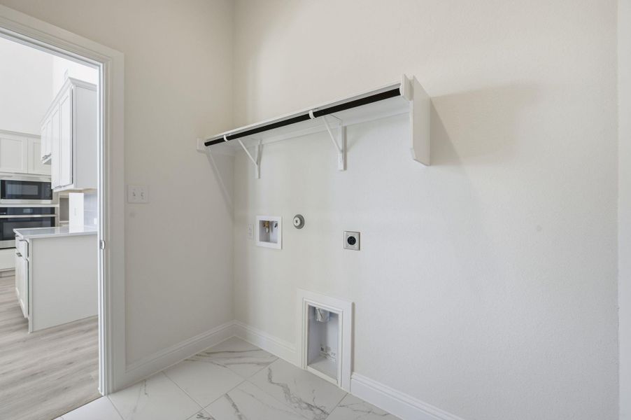 Laundry room featuring hookup for an electric dryer, washer hookup, hookup for a gas dryer, and light marble finish flooring