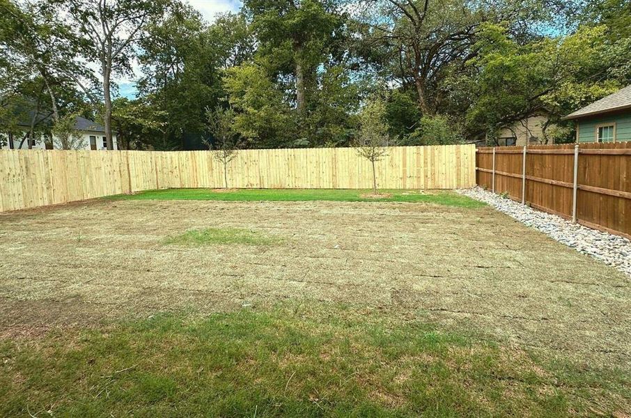Large sodded yard with oaks, fenced for privacy