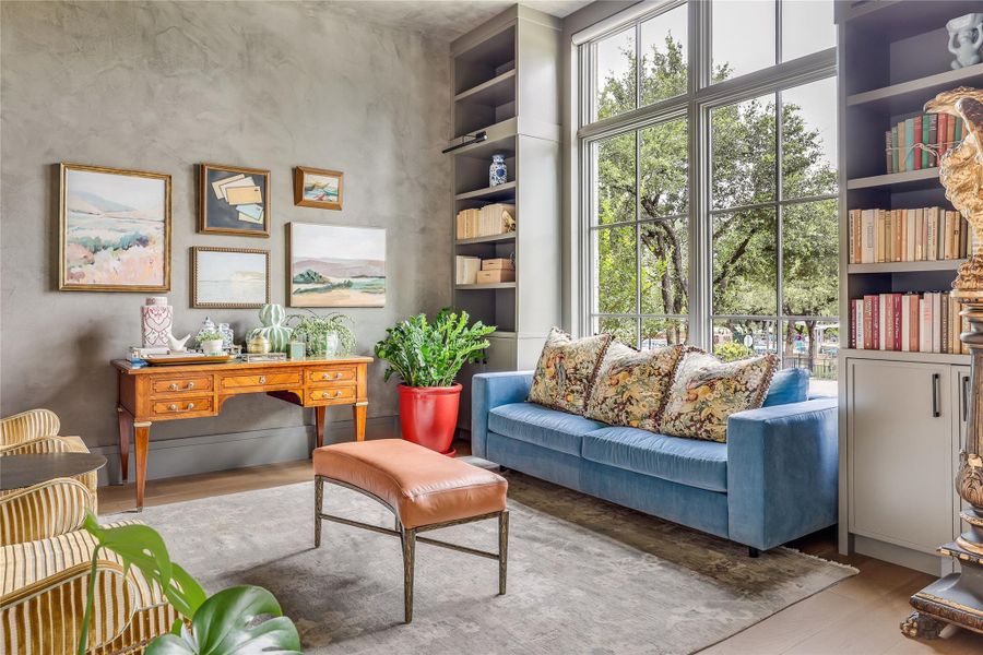 Natural light floods this inviting living space, complementing built-in shelving and views of mature trees.