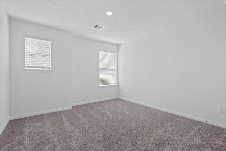 Bedroom 4 provides a quiet, comfortable retreat featuring fresh neutral paint, plush carpeting, and dual windows that welcome plenty of natural light. This well-proportioned secondary bedroom offers a highly versatile layout, making it an ideal space for a growing family or a dedicated guest room.