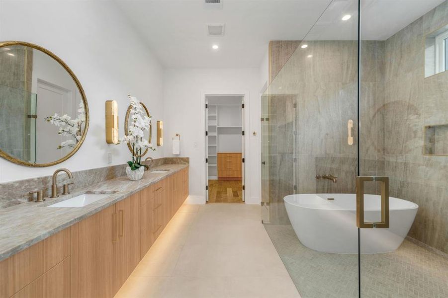 Full bathroom with double vanity, a soaking tub, a stall shower, a spacious closet, and recessed lighting Full bathroom with double vanity, a soaking tub, a stall shower, a spacious closet, and recessed lighting