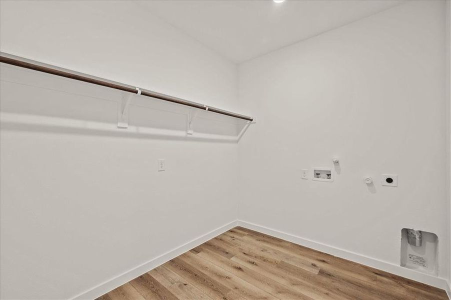 Laundry area with hookup for a gas dryer, hardwood / wood-style floors, electric dryer hookup, and washer hookup