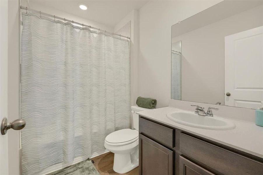 Bathroom with hardwood / wood-style flooring, toilet, and vanity