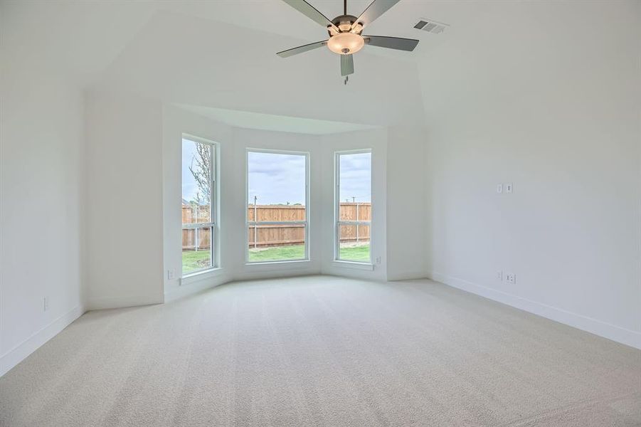 Carpeted spare room featuring baseboards and ceiling fan