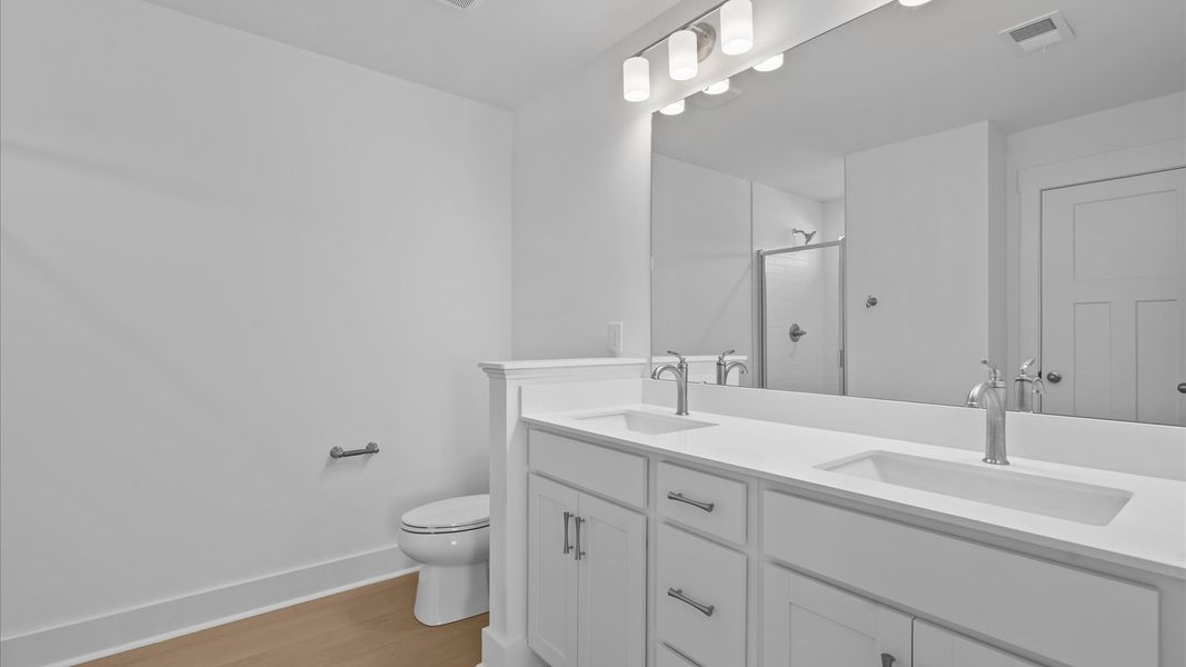Spacious and modern primary bathroom with walk-in shower and first-class double vanity setup