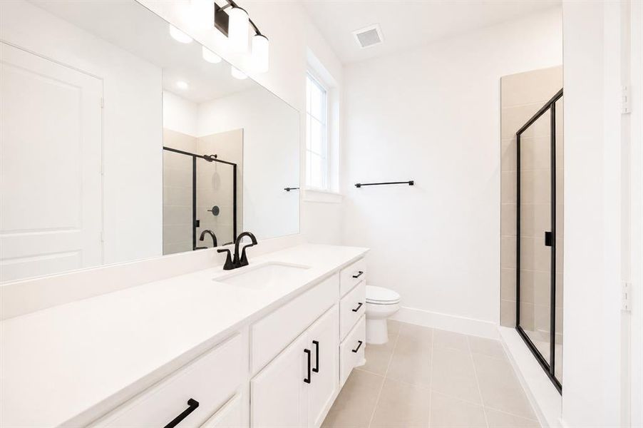 Contemporary bathroom featuring a spacious vanity with an undermount sink, white cabinetry, and matte black hardware