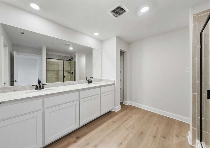 The master bathroom has a large vanity space, garden tub and glass, walk-in shower.