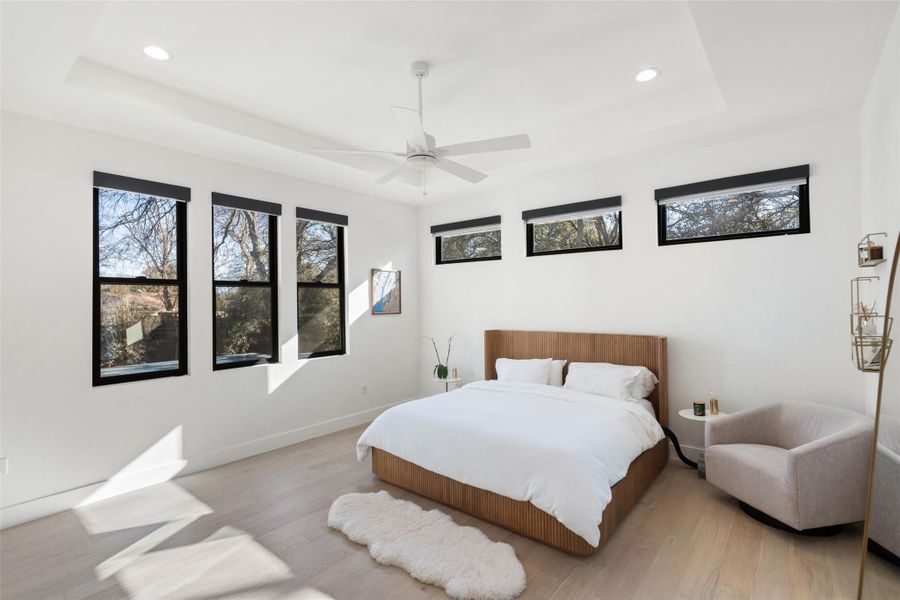 Spacious primary bedroom with automated Lutron blackout shades and large walk-in closet.