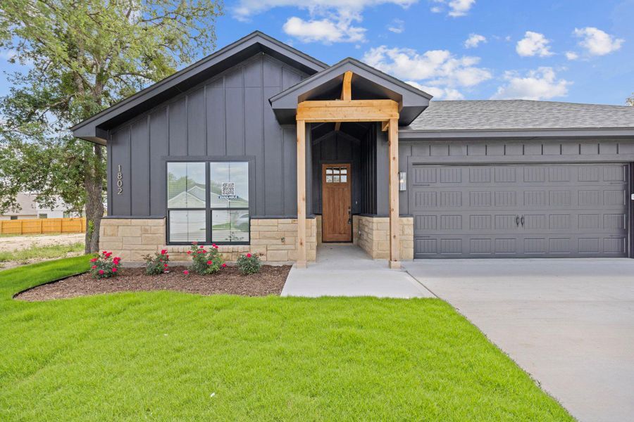 A striking facade with dark siding and stone accents provides inviting curb appeal. A striking facade with dark siding and stone accents provides inviting curb appeal.