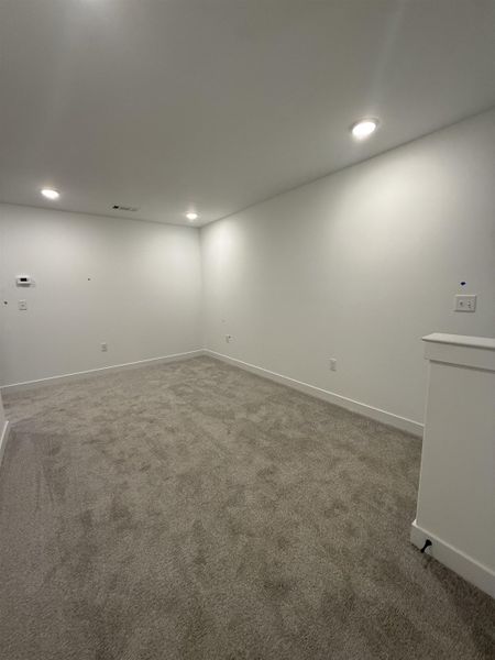 Carpeted spare room featuring baseboards and recessed lighting