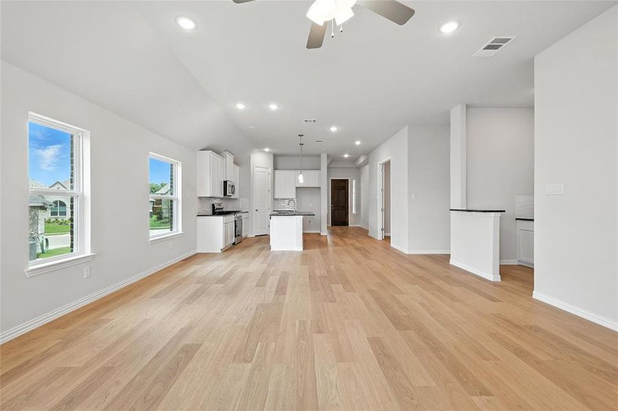 Unfurnished living room featuring ceiling fan, light wood-style floors, and recessed lighting Unfurnished living room featuring ceiling fan, light wood-style floors, and recessed lighting