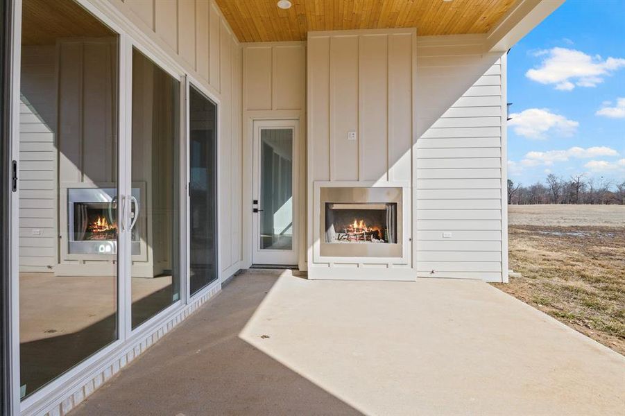 View of patio featuring a warm lit fireplace View of patio featuring a warm lit fireplace