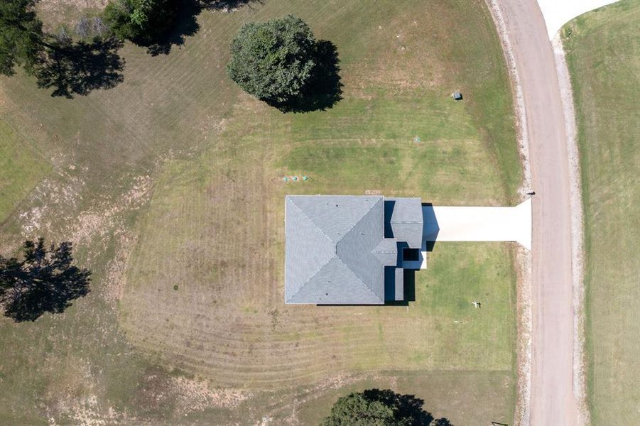 Single-story residence featuring a gray shingle roof and a concrete driveway Single-story residence featuring a gray shingle roof and a concrete driveway