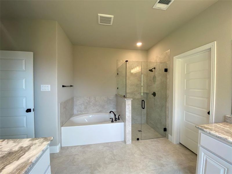 Master bath offers frameless glass shower & separate garden tub Master bath offers frameless glass shower & separate garden tub