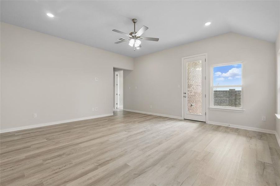 Spare room with ceiling fan, light wood-style floors, baseboards, recessed lighting, and vaulted ceiling