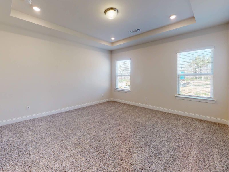 The plush primary suite offers a large walk-in closet, tray ceilings, and a luxurious bathroom. The plush primary suite offers a large walk-in closet, tray ceilings, and a luxurious bathroom.