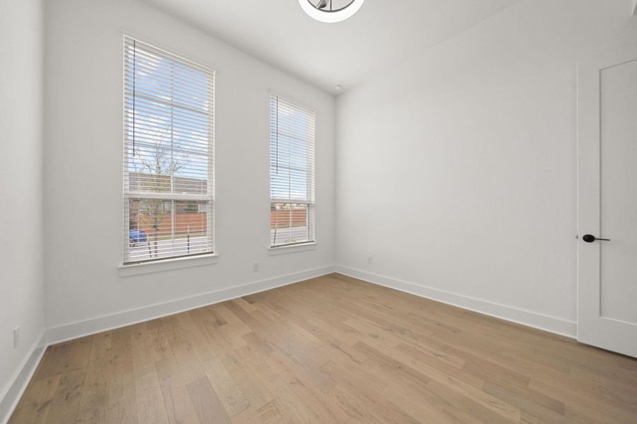 Spare room featuring light wood finished floors and baseboards
