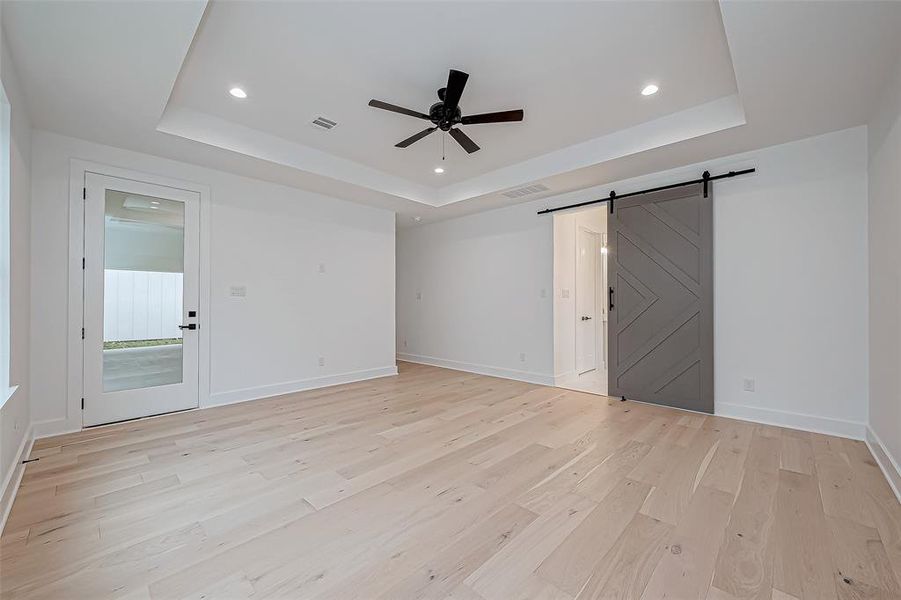 Primary bedroom with stylish sliding barn door for added character.